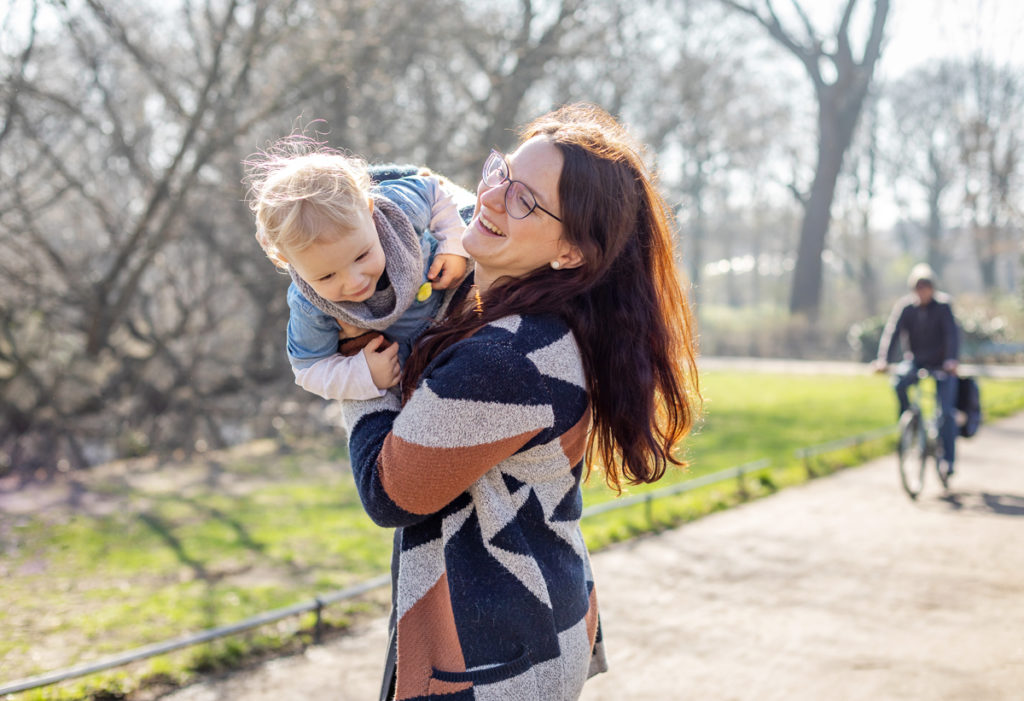 Mama mit Tochter auf dem Arm lachen