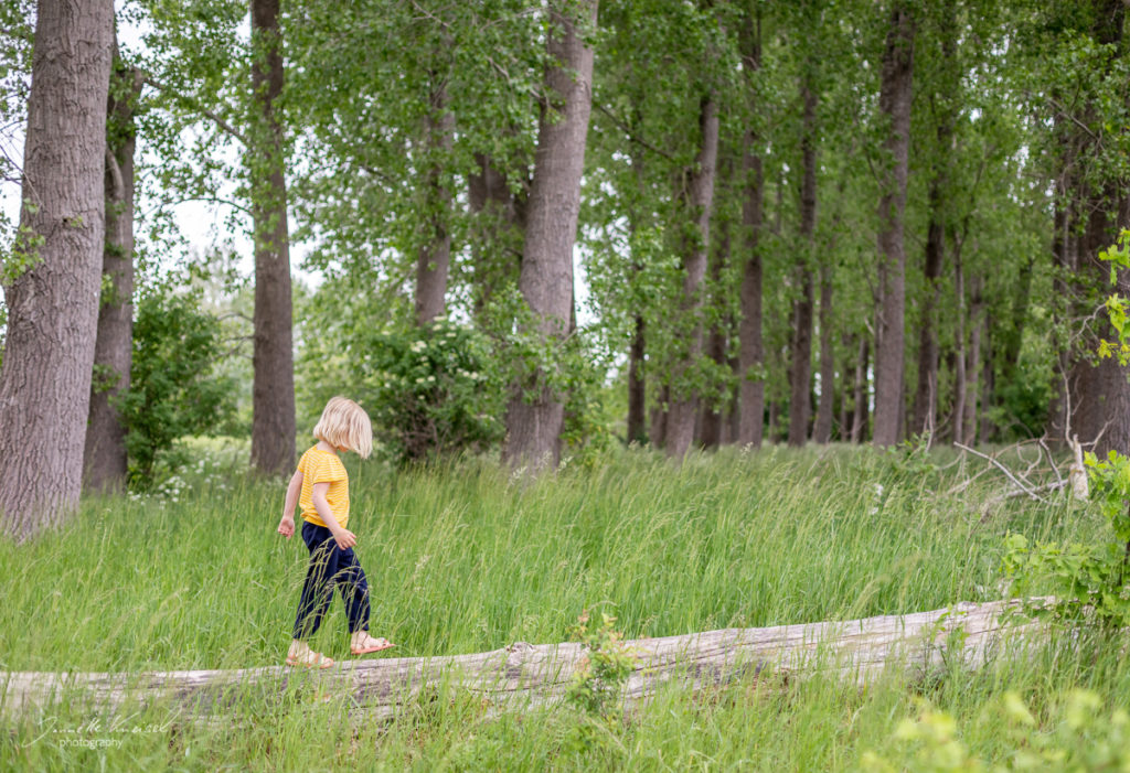 Kind balamziert auf Baumstamm, Shooting in der Natur